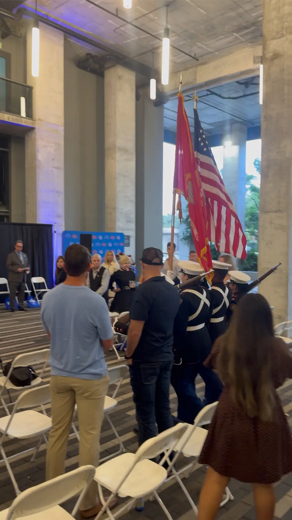 A color guard and attendees gathering at the Never Forget event.
